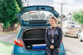 Meals on Wheels volunteer stands with her car