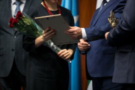 A woman receiving an award from a presenter.