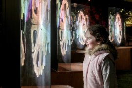 A girl looking at bright screens outside in the dark
