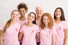 A group of diverse women wearing the breast cancer pink riboon
