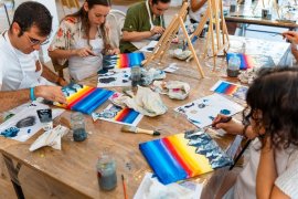 A group of people painting on canvas.