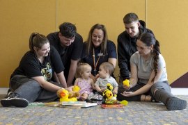 Young parents, their babies and a Knox staff member.