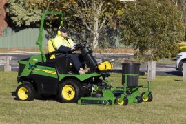 Image of worker driving large mowing machine in local reserve