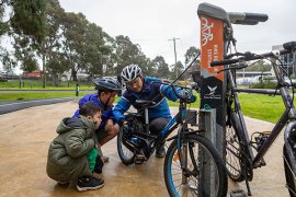 Father and two children using a bike repair station