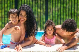 Parents and two children in a backyard pool