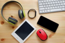 Headphones, smartwatch, keyboard, mouse, smartphone and tablet on a table
