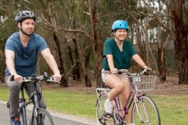 Male and female cycling on a pedal bike