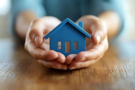 Person holding a house