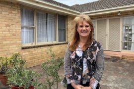 Jodi standing outside her home