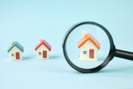 House figurines and a magnifying glass
