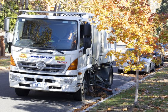 Street sweeping truck sweeping leaves