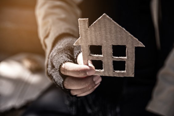 Person holding a cardboard house