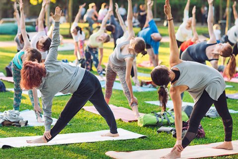Group of people outdoors performing yoga poses