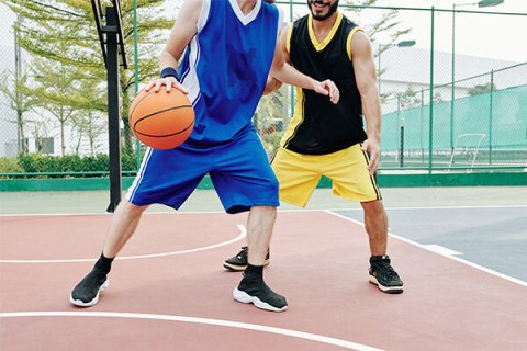 2 men playing basketball outdoors