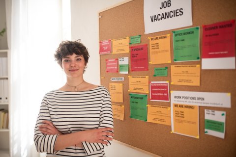 Person in front of a jobs board.