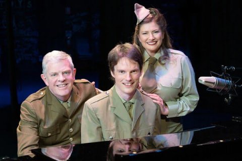 Three performers behind a grand piano wearing military attire
