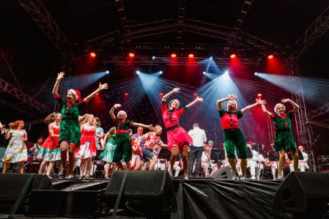 Dancers dressed as Christmas elves dancing on a stage
